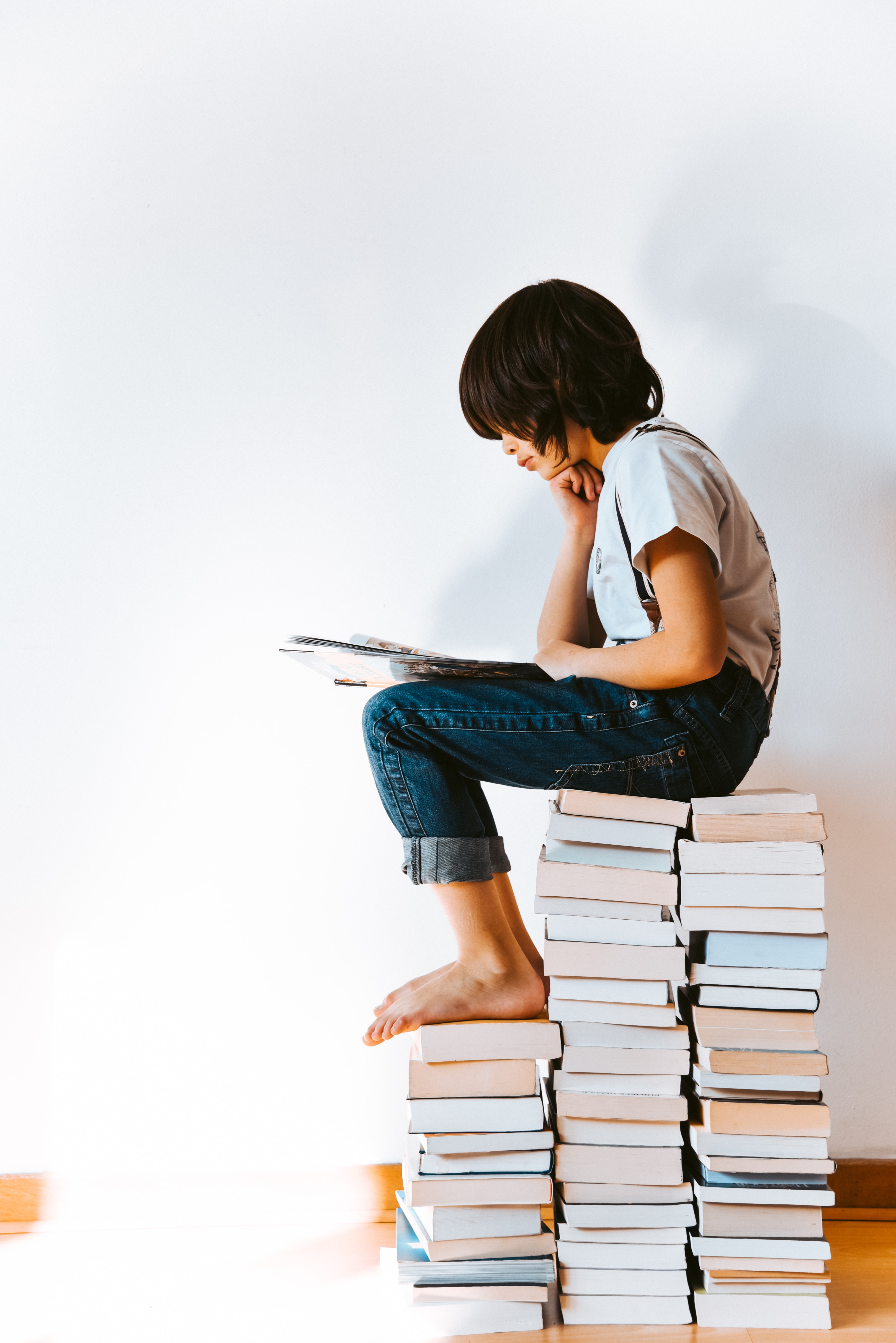 Child reading on tower of books (1)